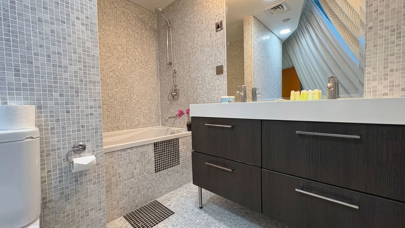 Second bathroom finished in mosaic tile with a long twin vanity, bath and walk-in shower
